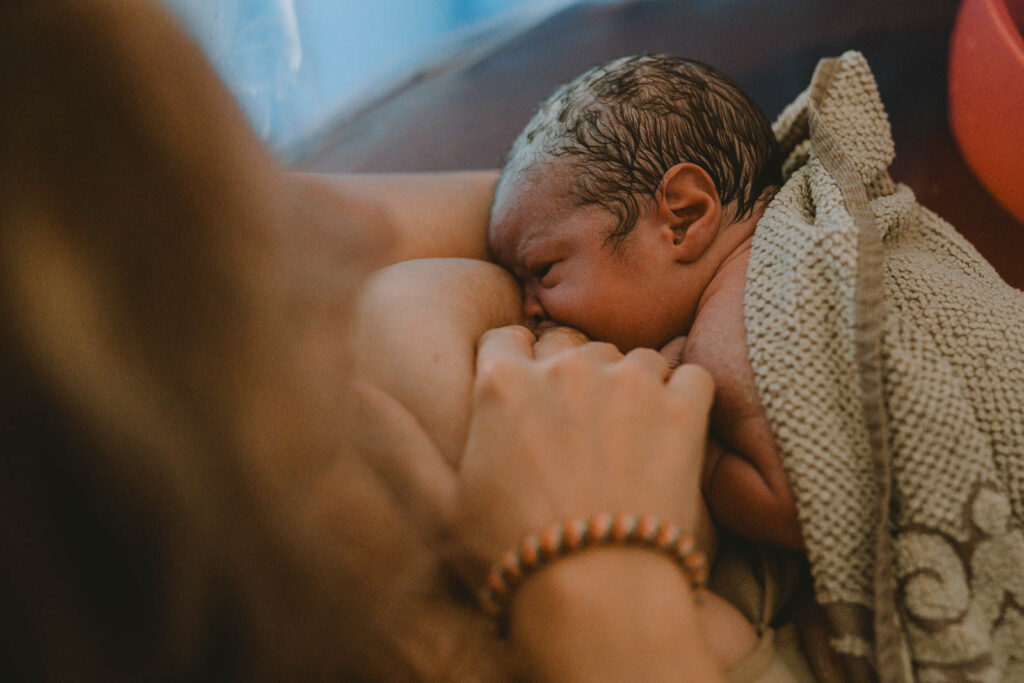 Neugeborenes an Mamas Brust in Geburtspool